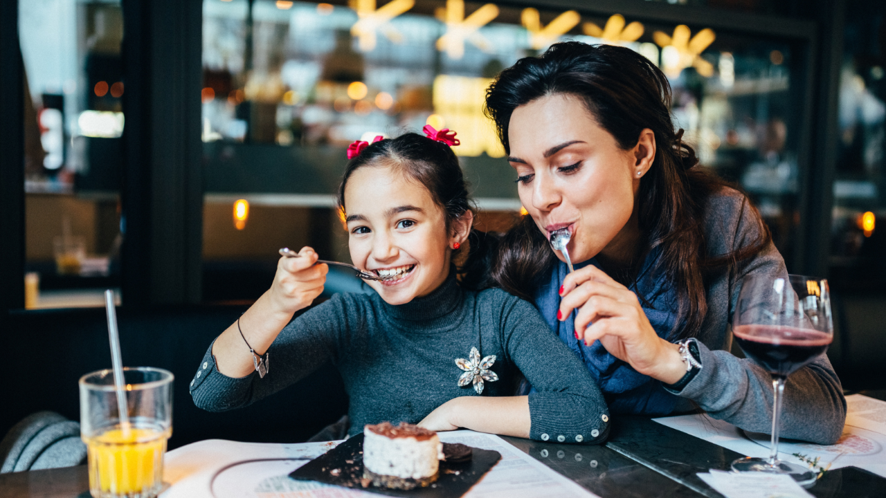 Mother and daughter enjoying food in restaurant